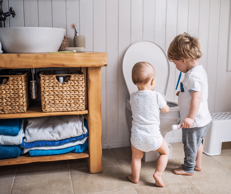 toddler and baby at toilet